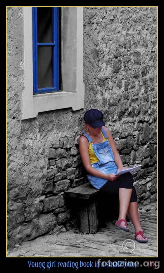 young girl reading book in a small town